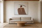 The Balancing Woman shown at 130 × 130 cm above a 240 cm linen sofa